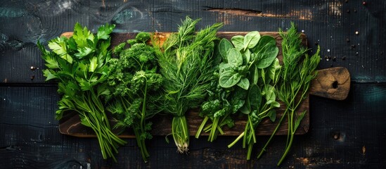 Aufkleber - Copy space image of various fresh greens like spinach dill parsley sorrel and green onions on a rustic cutting board atop a dark aged wooden surface in a top down perspective