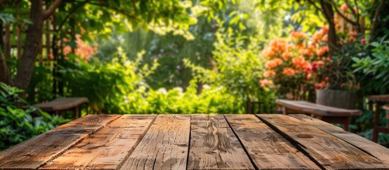 Poster - A wooden table set against a garden backdrop perfect for decoration with ample copy space image