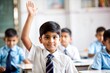 © N7 - Indian schoolboy raising hand in classroom