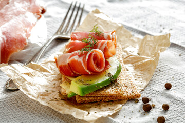 Wall Mural - Sandwiches with crispbread and cold cuts of black forest ham Schwarzwälder Schinken on a kitchen table with gray tablecloth. Copy space for food and drink and products. Delicious nutritious breakfast 