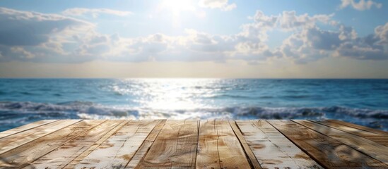 Canvas Print - Outdoor scenery featuring an empty wooden table with a spring sky blue sea and blurred bokeh effect ideal for counter display concepts with copy space image