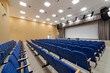 © FedotovAnatoly - Empty auditorium hall. Conference room interior with a stage and blue chairs
