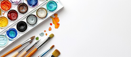 Poster - Art supplies including a paintbrush watercolors and a pencil are laid out on white paper with ample room for text message in the copy space image
