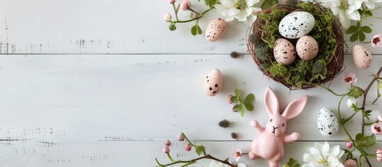 Aufkleber - Top view of an Easter themed banner arrangement featuring flowers a nest with speckled eggs and moss on a white wooden backdrop alongside a pink bunny figurine with copy space image