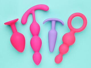 sex toys background. anal plugs and dildo over blue paper backdrop