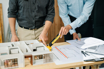 Wall Mural - two colleagues discussing data working and tablet, laptop with architectural project at construction
