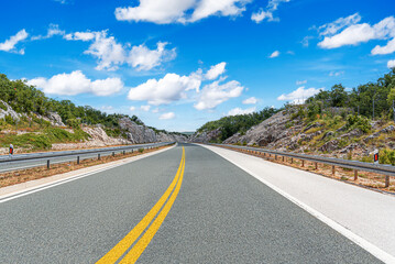 Wall Mural - Country road with rocky mountains in the background.