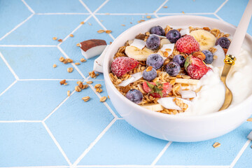 Breakfast yogurt granola bowl with fruit and berry