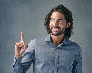 Studio, thinking and business man with pointing for announcement, promotion and smile with pride. Professional career, sales assistant and hand gesture for marketing deal, choice and gray background