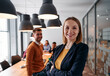 © .shock - Confident Blonde Businesswoman Leading Team in Modern Office Setting.
