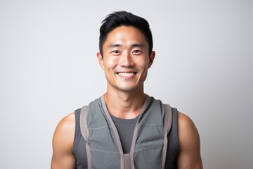 Sticker - Portrait of a grinning asian man in his 30s dressed in a breathable mesh vest on white background