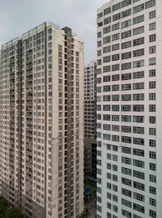 Wall Mural - Massive hi rise residential building facades aerial view in vertical format. Details of housing development featuring several towers shot during the day.