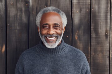 Poster - Portrait of a grinning afro-american man in his 70s dressed in a comfy fleece pullover in rustic wooden wall