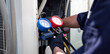© kunakorn - Air conditioning, HVAC service technician using gauges to check refrigerant and add refrigerant,Air Conditioning Repair, repairman on the floor fixing air conditioning system.