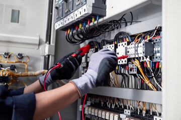 Wall Mural - Electricity and electrical maintenance service,Electrical tests industrial electrical circuits with a multimeter in the control terminal box.