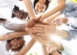© Prostock-studio - Student Friendship. Portrait of happy university friends stacking hands together, showing unity and togetherness, low angle view, selective focus