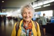 © Markus Schröder - Portrait of a grinning elderly woman in her 90s sporting a breathable hiking shirt on busy airport terminal