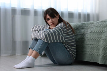 Poster - Loneliness concept. Sad woman sitting on floor at home