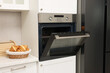 © New Africa - Open electric oven and croissants in kitchen. Cooking appliance
