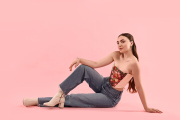 Wall Mural - Beautiful woman in stylish corset posing on pink background