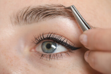 Sticker - Beautician plucking young woman's eyebrow, closeup view