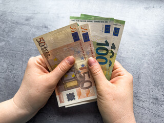 Poster - female holds counts euro money. Businesswoman's hand show big eur bills