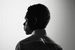 © SKIMP Art - a black man in profile, seen from behind wearing a business shirt on a white background, backlit in the style of a black and white photography Generative AI