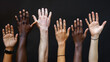 © Anna Iluschenko - Shot of a group of human hands of different nationalities reaching up against a dark background. The concept of combating racial discrimination. International Day of People of African Descent.
