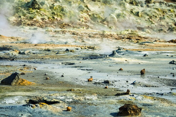 Lifeless rocky sulfur terrain hot springs with boiling water and steam coming out in Iceland