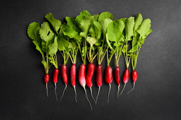 Fresh ripe radishes with green leaves. Organic food. On a gray concrete background.