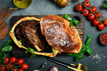 Wall Mural - Baked turkey thigh with tomatoes, bell pepper. Traditional Turkish dish. On a black stone background.