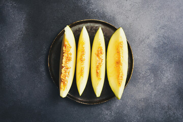 Wall Mural - Vintage plate with pieces of sliced ​​yellow melon. Rustic style. Top view.