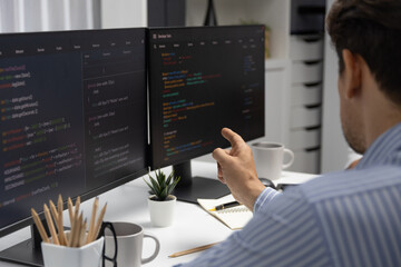 Wall Mural - it developer man pointing information on laptop screen at back side view, thinking program update an
