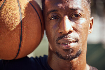 Basketball, sport and face with a man training with a ball for health, workout and fitness. Motivation, sports and exercise with a young male athlete playing a game or match on a court outside