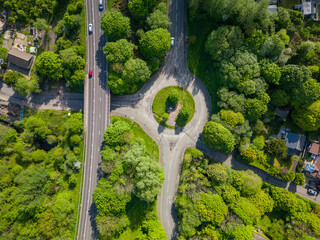 Canvas Print - Top down aerial view of a small roundabout surrounded by lush foliage during summer