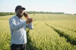 © Serhii - An African farmer is talking on the phone while standing in a wheat field. The concept of agrarian business