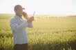 © Serhii - Farmer is standing in his growing wheat field. He is satisfied after successful sowing