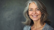 © iamfrk7 - Smiling mature woman with grey hair, natural beauty, close-up portrait highlighting confidence and grace, senior lifestyle, positive aging, grey background