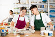 © JackF - Young man and young woman making pottery from clay in workshop