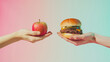 © Hound - Two hands reaching for an apple and burger, symbolizing the choice between healthy eating or fast food against a solid background