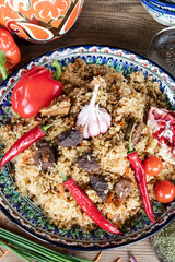 freshly prepared delicious pilaf on a colorful dish decorated with vegetables. View from above.