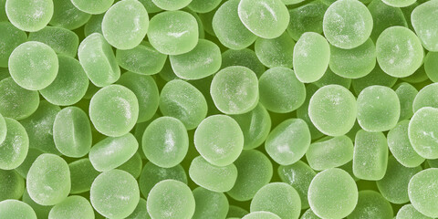 A cute and dreamy, aesthetic background of close-up of round shaped pastel green gummy candy, each piece showcasing its chewy texture and sugar-coated finish