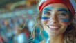 © Five Million Stock - Happy French woman supporter with face painted in French flag colors, blue white and red, fan at a sports event such as football or rugby match, blurry stadium background and copy space