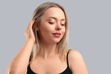 Wall Mural - Pretty young woman on grey background. Skin care concept