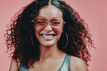 Poster - Woman, sunglasses and smile in studio for beauty, cosmetic and happy on pink background. Curly hair, colour and bold for model people, glam and glow for creative cosmetology and aesthetic for makeup