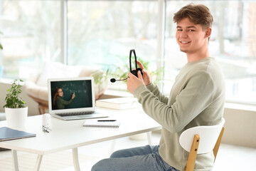 Canvas Print - Male student with headset studying Math online at home