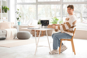 Poster - Male student with books studying Math online at home