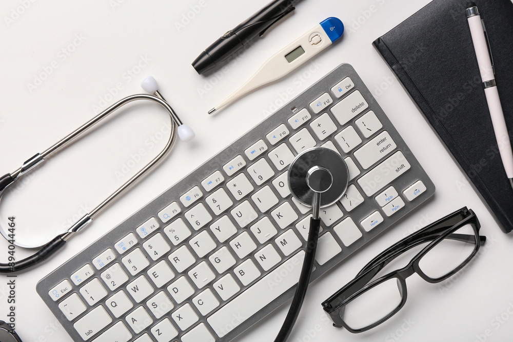 Composition with modern keyboard, medical supplies and eyeglasses on light background, closeup