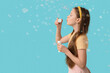 © Pixel-Shot - Cute girl blowing soap bubbles on blue background