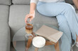 © Pixel-Shot - Young woman with glass of tasty iced latte sitting on sofa at home